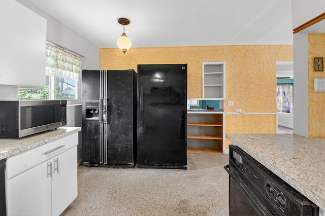 1115 S Seacrest Blvd, Boynton Beach, FL 33435 - kitchen with black fridge, stainless steel microwave, freestanding refrigerator, light countertops, and white cabinetry