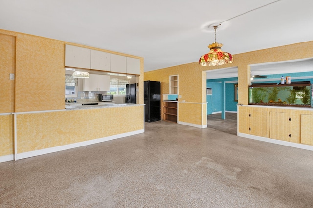 1115 S Seacrest Blvd, Boynton Beach, FL 33435 - kitchen featuring stainless steel microwave, dark speckled floor, hanging light fixtures, white cabinets, and baseboards