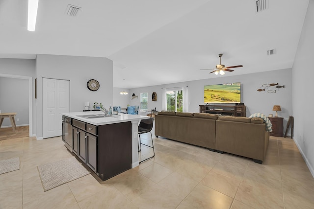 191 SW Glenwood Dr, Port Saint Lucie, FL 34984 - kitchen featuring vaulted ceiling, open floor plan, a sink, a ceiling fan, and a center island with sink