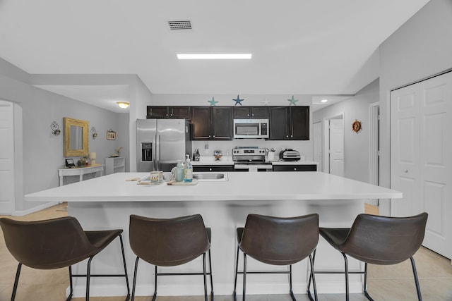 191 SW Glenwood Dr, Port Saint Lucie, FL 34984 - kitchen with appliances with stainless steel finishes, light countertops, a spacious island, and a breakfast bar area