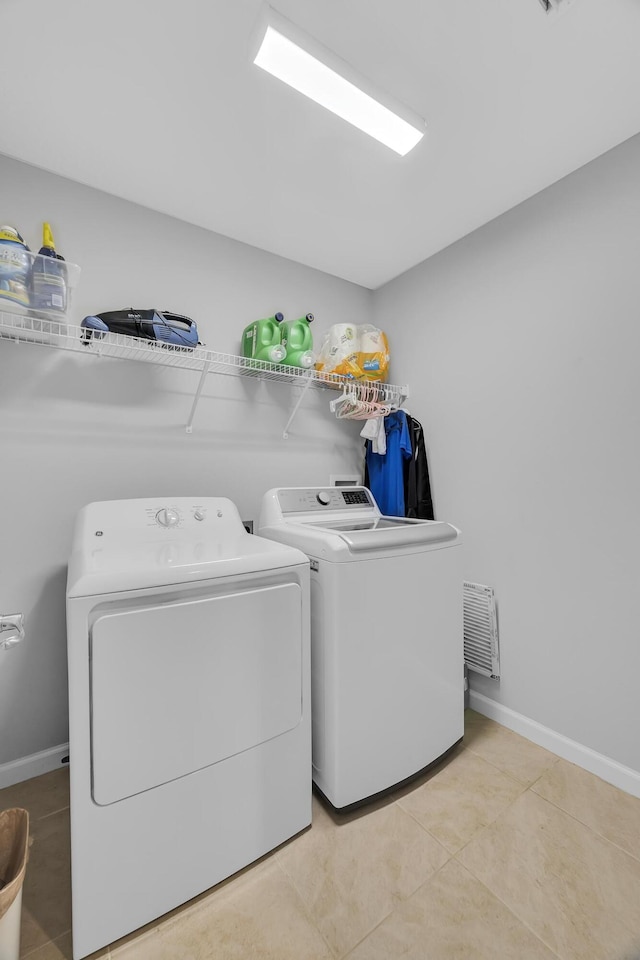 191 SW Glenwood Dr, Port Saint Lucie, FL 34984 - washroom with washer and clothes dryer, baseboards, and light tile patterned flooring