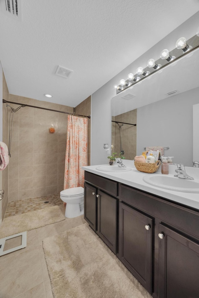 191 SW Glenwood Dr, Port Saint Lucie, FL 34984 - full bath with double vanity, tiled shower, toilet, tile patterned flooring, and a textured ceiling