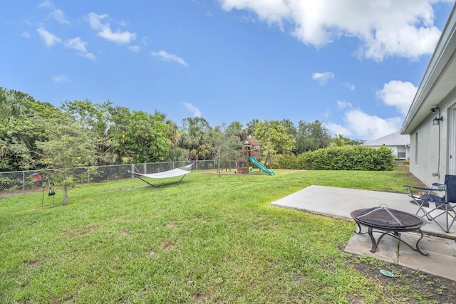 191 SW Glenwood Dr, Port Saint Lucie, FL 34984 - view of yard featuring a fire pit, a patio area, and a playground