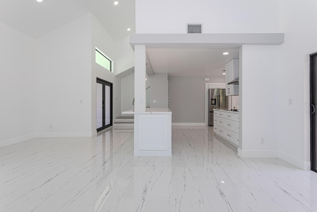 102 Granada St, Royal Palm Beach, FL 33411 - unfurnished living room featuring light marble finish floors, baseboards, recessed lighting, and a high ceiling