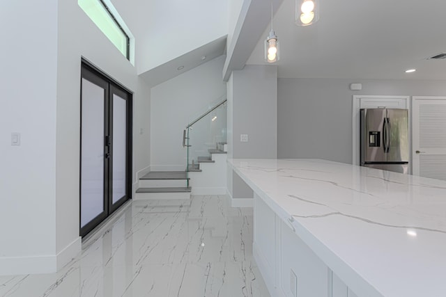 102 Granada St, Royal Palm Beach, FL 33411 - kitchen with stainless steel fridge, light marble finish flooring, light stone counters, baseboards, and pendant lighting