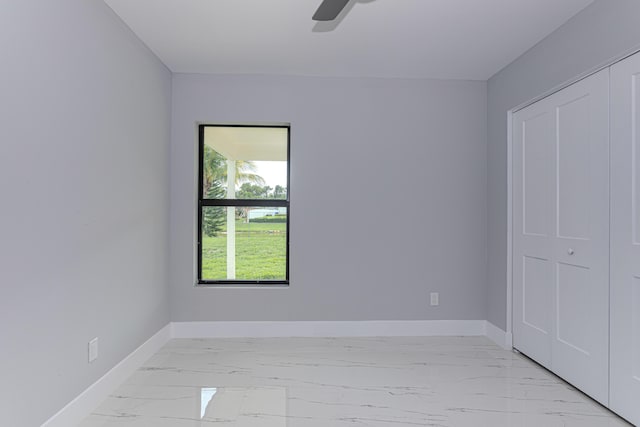 102 Granada St, Royal Palm Beach, FL 33411 - unfurnished bedroom with baseboards, light marble finish floors, ceiling fan, and a closet