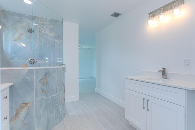 102 Granada St, Royal Palm Beach, FL 33411 - bathroom with vanity, a marble finish shower, wood finished floors, and baseboards
