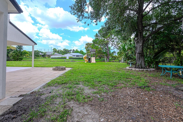 102 Granada St, Royal Palm Beach, FL 33411 - view of grassy yard with a playground, a fire pit, and a patio area
