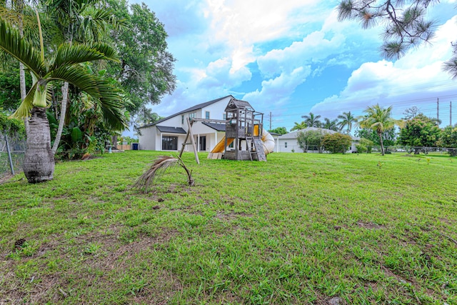 102 Granada St, Royal Palm Beach, FL 33411 - back of property with a playground and a lawn