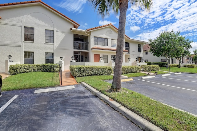 9692 Sills Dr E Unit 103, Boynton Beach, FL 33437 - view of building exterior with uncovered parking