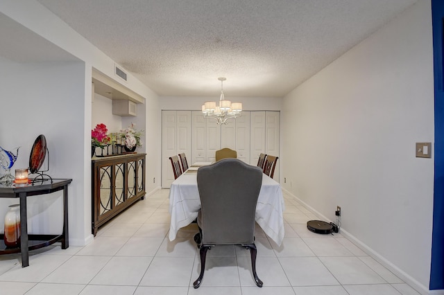 9692 Sills Dr E Unit 103, Boynton Beach, FL 33437 - dining room featuring a chandelier, a textured ceiling, light tile patterned floors, and baseboards