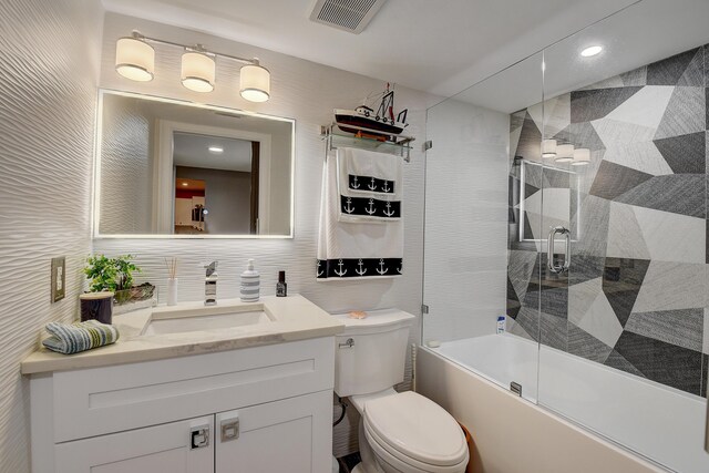 9692 Sills Dr E Unit 103, Boynton Beach, FL 33437 - bathroom featuring vanity, combined bath / shower with glass door, toilet, tasteful backsplash, and tile walls
