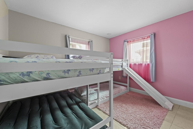 1528 Singletary Ave, Pahokee, FL 33476 - tiled bedroom featuring multiple windows and baseboards