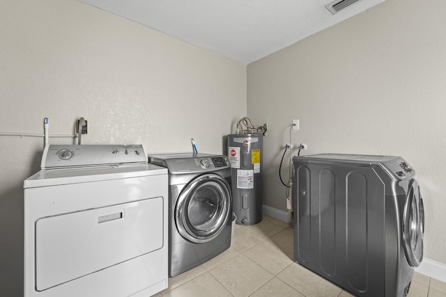 1528 Singletary Ave, Pahokee, FL 33476 - laundry room featuring water heater, washing machine and clothes dryer, light tile patterned flooring, and baseboards