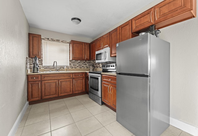 1528 Singletary Ave, Pahokee, FL 33476 - kitchen featuring stainless steel appliances, a sink, light countertops, backsplash, and baseboards