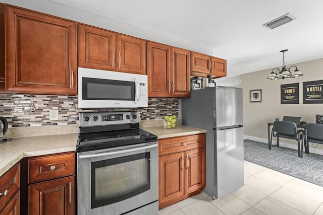 1528 Singletary Ave, Pahokee, FL 33476 - kitchen with appliances with stainless steel finishes, a chandelier, light countertops, and backsplash
