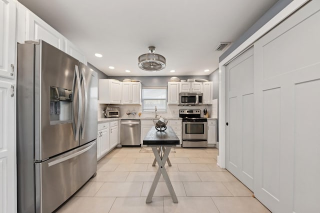 1056 SW 27th Ave, Boynton Beach, FL 33426 - kitchen with appliances with stainless steel finishes, light countertops, white cabinets, recessed lighting, and decorative backsplash