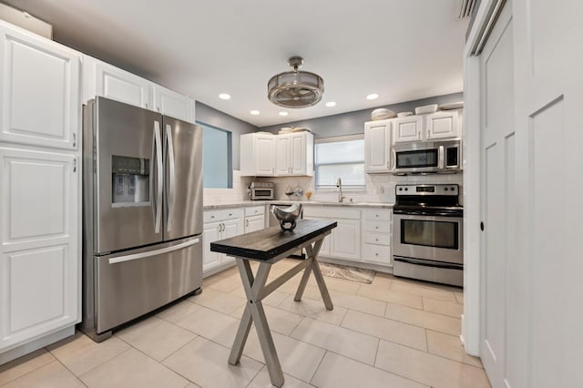 1056 SW 27th Ave, Boynton Beach, FL 33426 - kitchen featuring stainless steel appliances, decorative backsplash, white cabinets, a sink, and recessed lighting