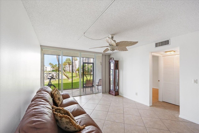 1950 SW Palm City Rd Unit 5109, Stuart, FL 34994 - living room featuring a textured ceiling, a ceiling fan, light tile patterned flooring, and expansive windows