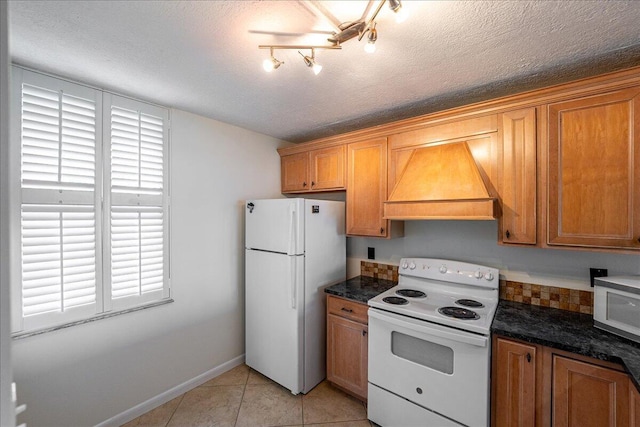 1950 SW Palm City Rd Unit 5109, Stuart, FL 34994 - kitchen with white appliances, custom range hood, a textured ceiling, light tile patterned floors, and brown cabinets