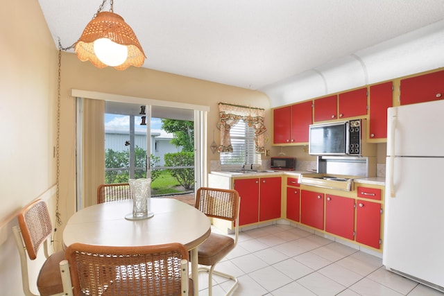 1916 SW 19th St, Boynton Beach, FL 33426 - kitchen featuring red cabinets, freestanding refrigerator, stainless steel microwave, black microwave, and light countertops