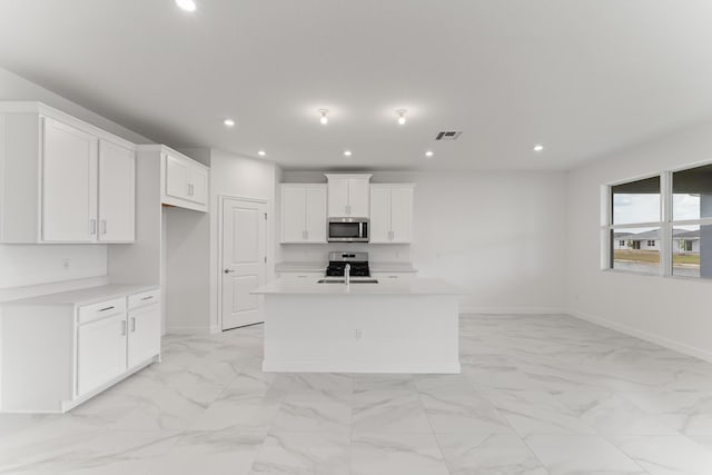 14483 SW Woodford Way, Port Saint Lucie, FL 34987 - kitchen with stainless steel microwave, light marble finish floors, range, light countertops, and a center island with sink