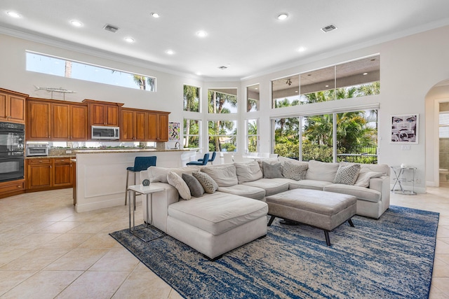 16414 Braeburn Ridge Trl, Delray Beach, FL 33446 - living room featuring a high ceiling, ornamental molding, light tile patterned floors, arched walkways, and recessed lighting