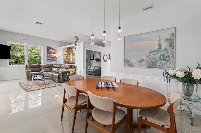 137 N Lakeshore Dr, Hypoluxo, FL 33462 - dining room with wainscoting, light tile patterned flooring, and a decorative wall
