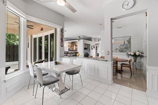 137 N Lakeshore Dr, Hypoluxo, FL 33462 - dining space featuring ceiling fan, wainscoting, and light tile patterned floors
