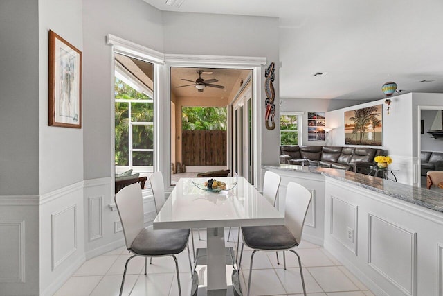 137 N Lakeshore Dr, Hypoluxo, FL 33462 - dining space featuring wainscoting, light tile patterned floors, and a ceiling fan