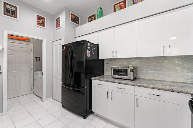 137 N Lakeshore Dr, Hypoluxo, FL 33462 - kitchen with freestanding refrigerator, backsplash, white cabinets, light tile patterned floors, and separate washer and dryer