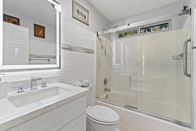 137 N Lakeshore Dr, Hypoluxo, FL 33462 - full bath with vanity, shower / bath combination with glass door, toilet, and tile walls