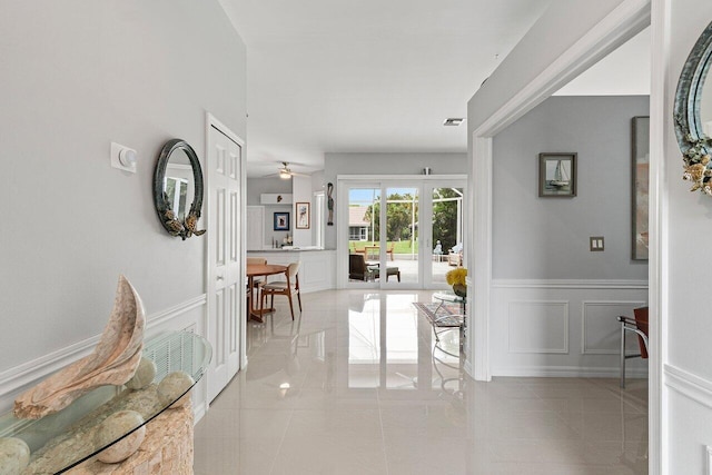 137 N Lakeshore Dr, Hypoluxo, FL 33462 - corridor with french doors, wainscoting, a decorative wall, and light tile patterned floors