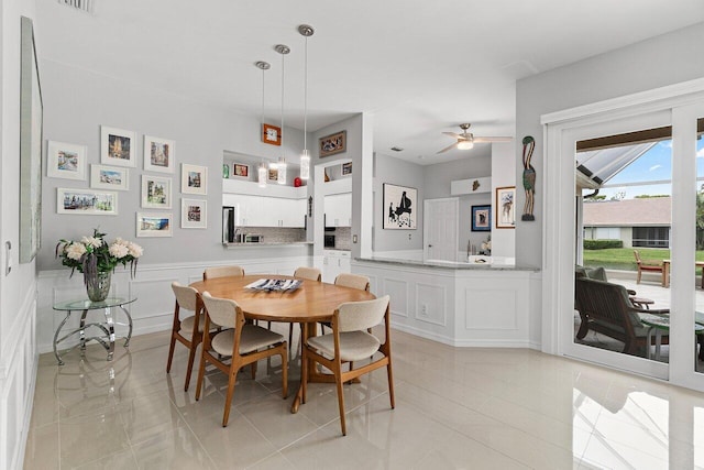 137 N Lakeshore Dr, Hypoluxo, FL 33462 - dining space with a ceiling fan and wainscoting