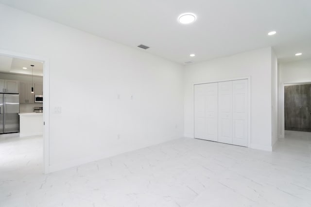 4209 25th St SW, Lehigh Acres, FL 33976 - unfurnished bedroom featuring stainless steel fridge, light marble finish floors, recessed lighting, a closet, and baseboards