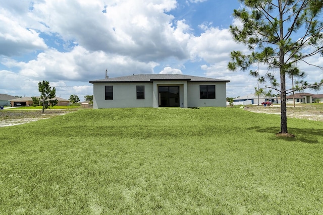 4209 25th St SW, Lehigh Acres, FL 33976 - rear view of property featuring stucco siding and a yard