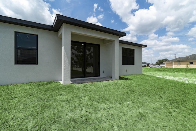 4209 25th St SW, Lehigh Acres, FL 33976 - back of house featuring stucco siding and a yard
