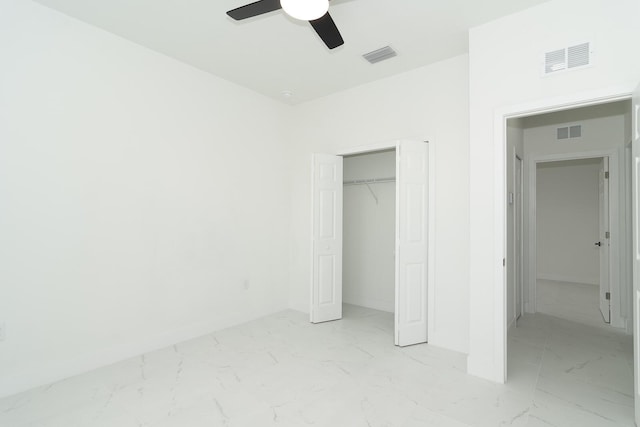 4209 25th St SW, Lehigh Acres, FL 33976 - unfurnished bedroom featuring light marble finish floors, a closet, and a ceiling fan
