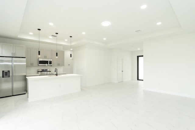 4209 25th St SW, Lehigh Acres, FL 33976 - kitchen with stainless steel appliances, a raised ceiling, a sink, a center island with sink, and recessed lighting