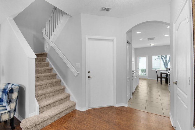 2186 SE Destin Dr, Port Saint Lucie, FL 34952 - stairway featuring arched walkways, wood finished floors, baseboards, and recessed lighting