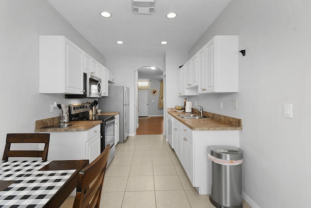 2186 SE Destin Dr, Port Saint Lucie, FL 34952 - kitchen with appliances with stainless steel finishes, a sink, arched walkways, recessed lighting, and baseboards