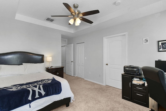 2186 SE Destin Dr, Port Saint Lucie, FL 34952 - bedroom featuring a tray ceiling, light colored carpet, an office area, baseboards, and a ceiling fan