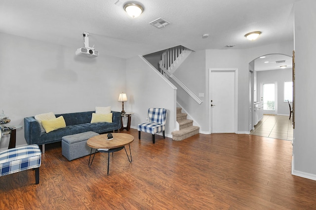 2186 SE Destin Dr, Port Saint Lucie, FL 34952 - living room with arched walkways, wood finished floors, stairs, baseboards, and a textured ceiling