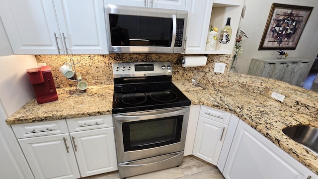 9587 Weldon Cir Unit B414, Tamarac, FL 33321 - kitchen with stainless steel appliances, decorative backsplash, and white cabinetry