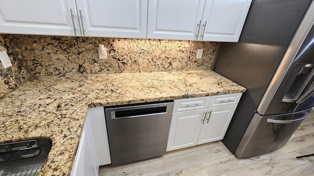 9587 Weldon Cir Unit B414, Tamarac, FL 33321 - kitchen featuring appliances with stainless steel finishes, white cabinets, light stone counters, and backsplash