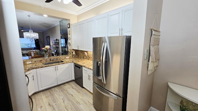 9587 Weldon Cir Unit B414, Tamarac, FL 33321 - kitchen featuring appliances with stainless steel finishes, light wood-style floors, a sink, ornamental molding, and white cabinets