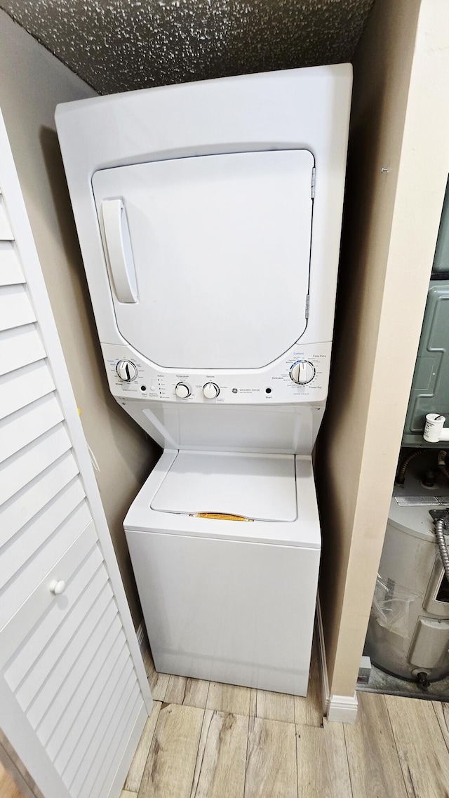 9587 Weldon Cir Unit B414, Tamarac, FL 33321 - laundry area featuring stacked washer / dryer and wood finished floors