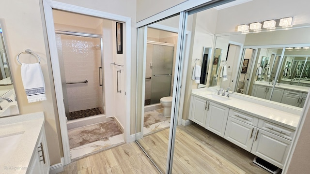 9587 Weldon Cir Unit B414, Tamarac, FL 33321 - full bathroom with toilet, two vanities, a stall shower, and wood finished floors