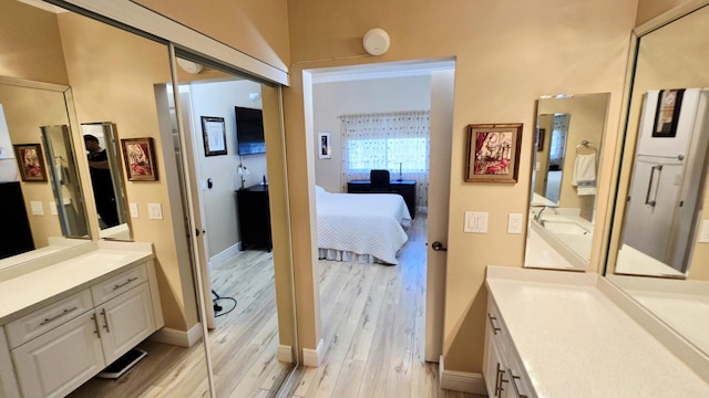 9587 Weldon Cir Unit B414, Tamarac, FL 33321 - bathroom featuring ensuite bath, two vanities, wood finished floors, and baseboards