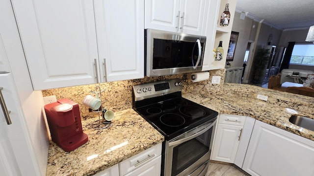 9587 Weldon Cir Unit B414, Tamarac, FL 33321 - kitchen featuring appliances with stainless steel finishes, tasteful backsplash, ornamental molding, and white cabinets